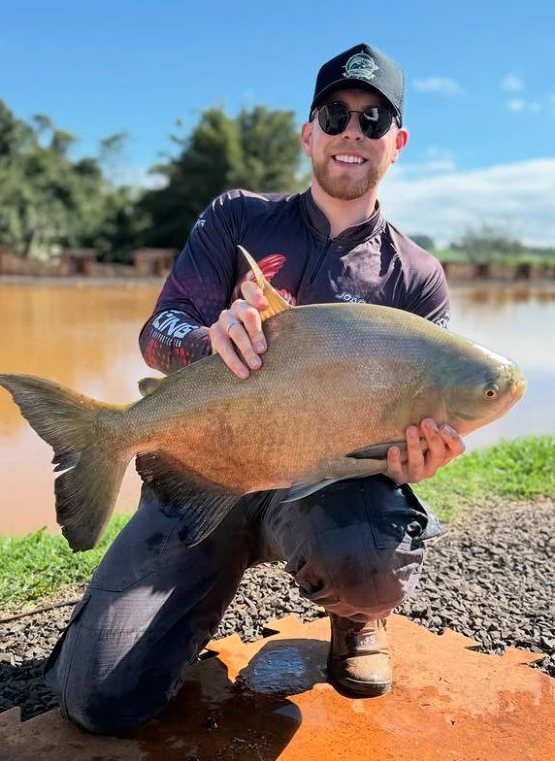 Pescador com camiseta King segurando um tambaqui